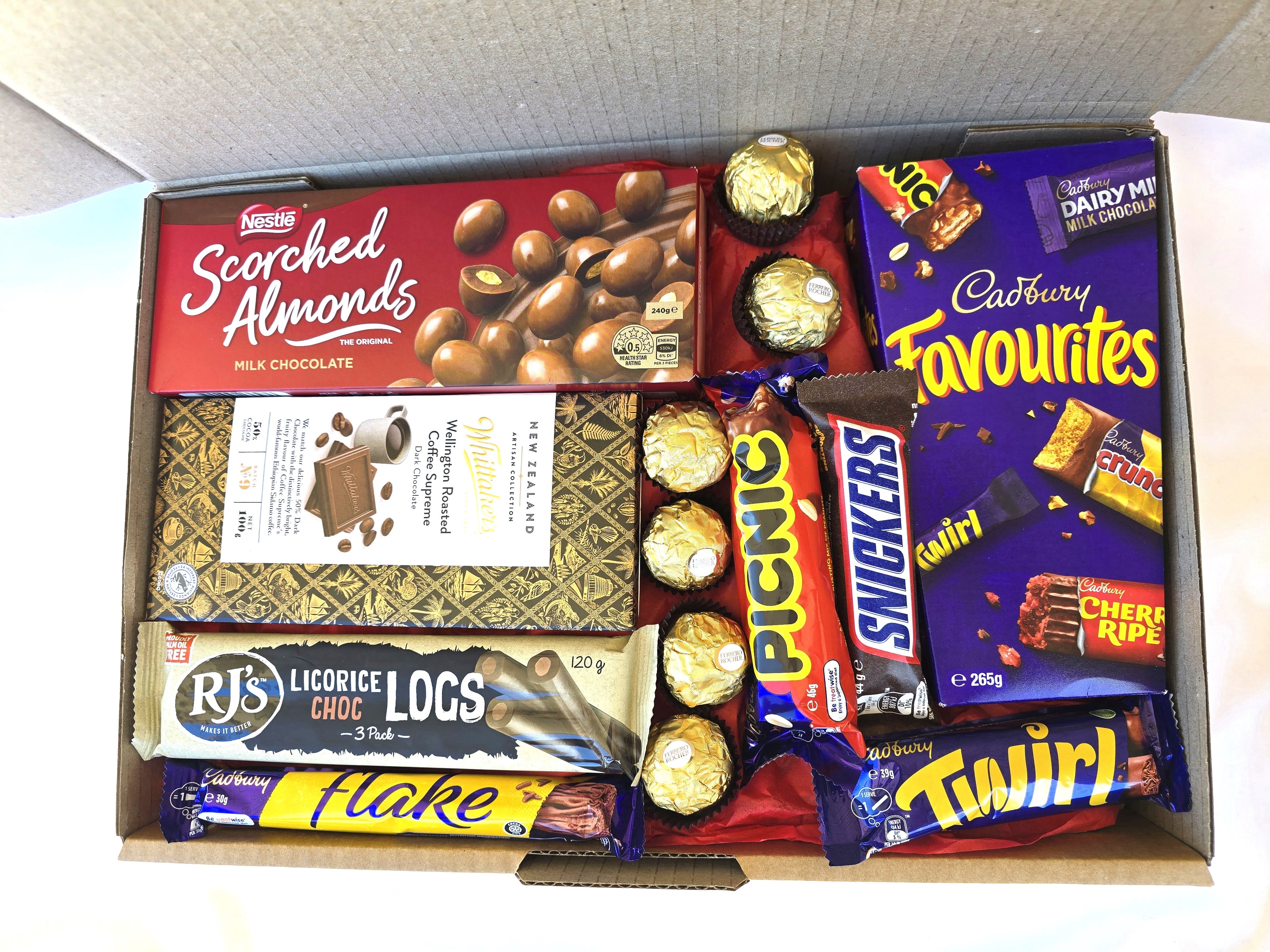 Assorted chocolate bars in a box including Cadbury, Rjs, and Picnic.