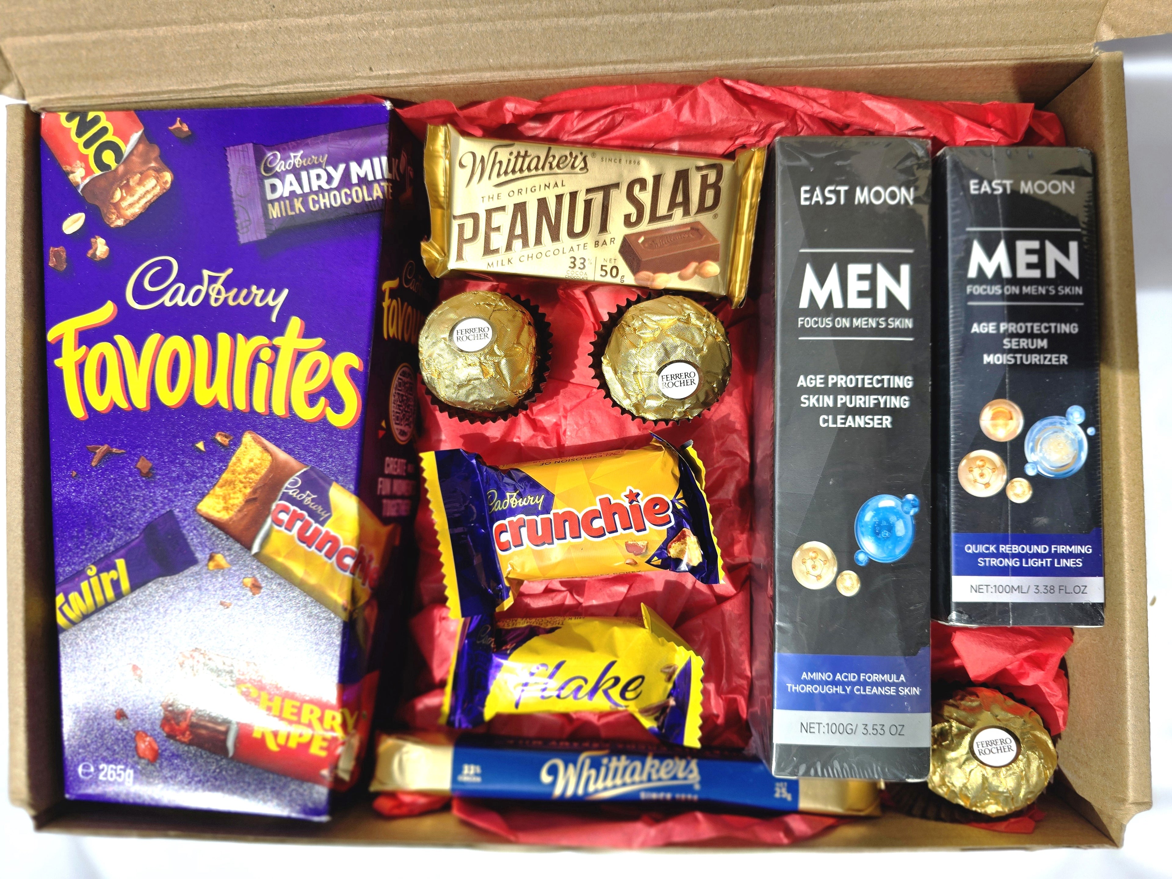 Box containing Cadbury Favourites, Nestle chocolate bars, and skincare products.